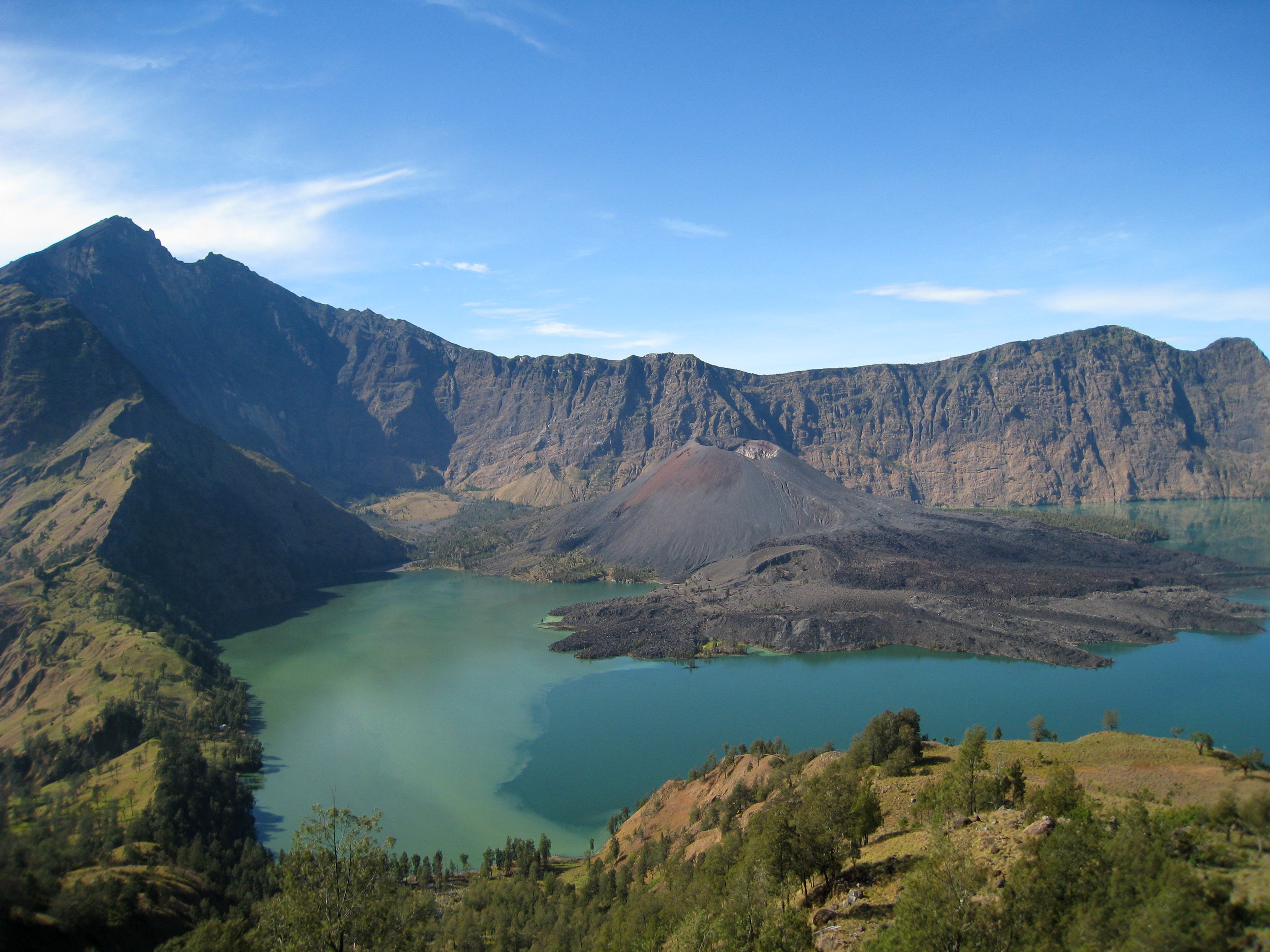 The caldera of Mount Rinjani. The turquoise Segara Anak lake and the cinder cone of Gunung Baru Jari, ringed by crater walls.